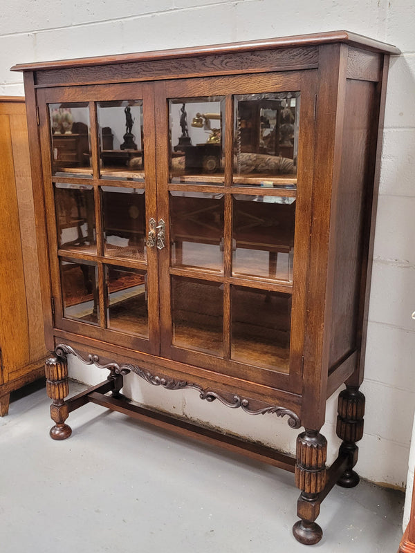 Tudor oak 2 door astral glaze and beveled glass bookcase.  Good original condition. Circa 1930s.