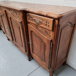 Parquetry top French oak Louis XV style sideboard with two draws and four cupboards. In good original detailed condition.