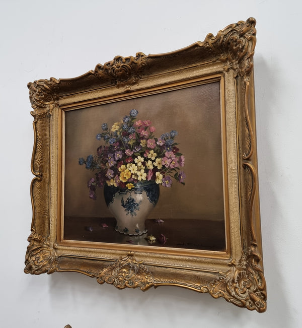 Attractive signed oil on canvas depicting flowers in a blue and white Jardinière in a stunning gilt frame. In good original detailed condition.