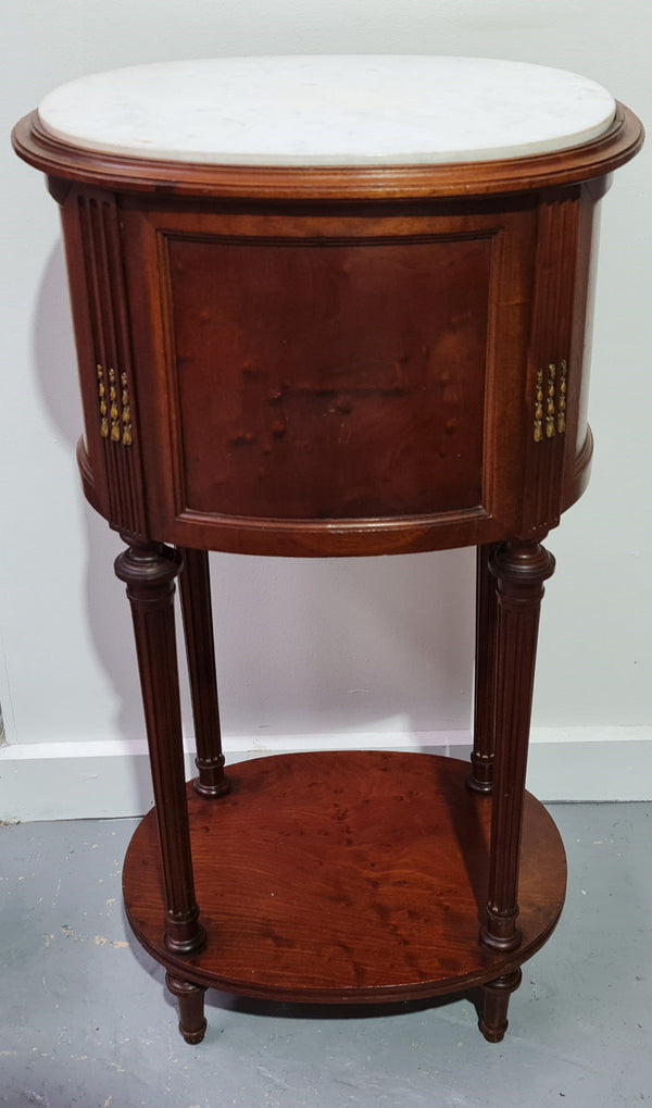 Round Louis XVI style Mahogany marble top side table. It has one drawer and a cupboard for storage. It is in good original detailed condition.