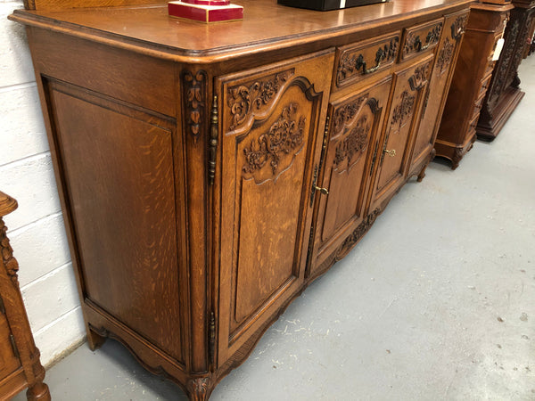 French Louis XV style Oak sideboard with beautiful carvings. Plenty Of storage space with four cupboards and two drawers. In very good original detailed condition.