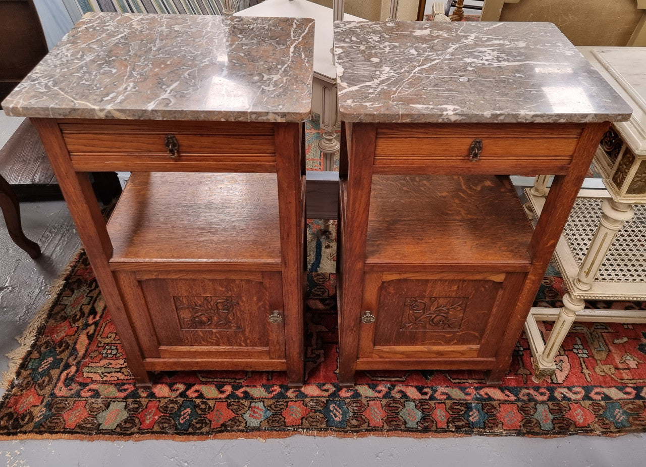 Charming pair of French Oak Arts and Crafts bedsides with shelf, cupboard with carving and marble top.  They have been sourced from France and are in good original detailed condition.