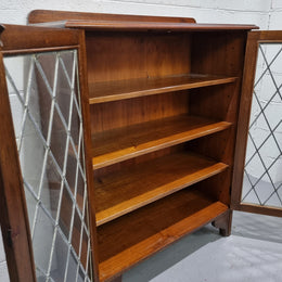 Lovely leadlight two door Oak bookcase/display cabinet with four wooden shelves. It is in good original detailed condition.