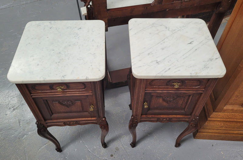 Pair French oak Louis XV style white carrera marble top bedside cabinets. Consisting of one drawer and one cupboard each on elegant legs. Circa: 1900's