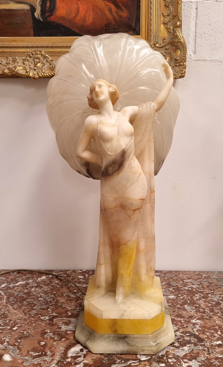 Monumental Art Deco alabaster and marble figural lamp modelled as a seductively dressed semi naked woman. In subtlety coloured diaphanous robes with a large clam shell light backdrop. Italian circa 1920's signed to base. This is a world class example of a true Art Deco sculpture lamp. It is in good original detailed condition, please view photos as they help form part of the description.