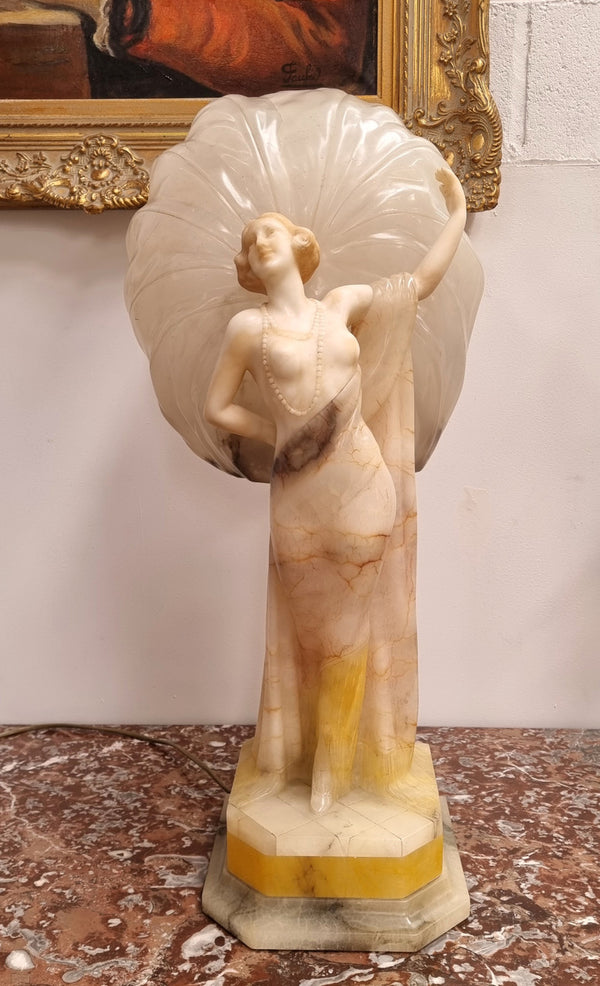 Monumental Art Deco alabaster and marble figural lamp modelled as a seductively dressed semi naked woman. In subtlety coloured diaphanous robes with a large clam shell light backdrop. Italian circa 1920's signed to base. This is a world class example of a true Art Deco sculpture lamp. It is in good original detailed condition, please view photos as they help form part of the description.