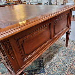 Substantial French Louis XVI style Oak partners desk. It has a beautiful leather top, two drawers on either side and decorative carvings throughout. Sourced from France and in good original detailed condition.
