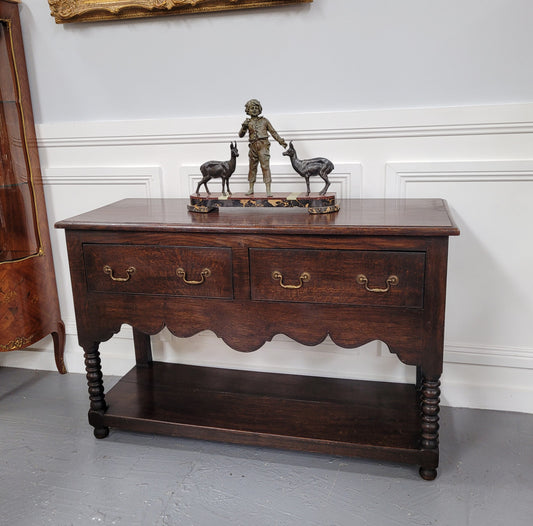 Rare size 19th Century English oak dresser base. It has two good size drawers and amazing patina. It has been sourced from France and in good original detailed condition.