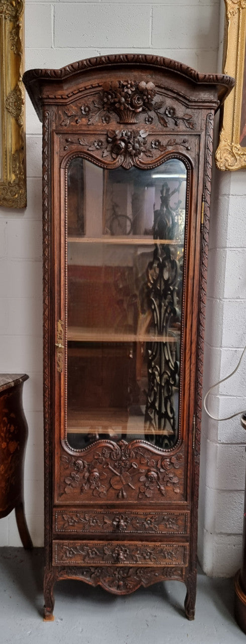 Petite oak armoire display cabinet with a glass door, two drawers at the bottom and three shelves inside. Late 18th Century and amazing detailed decorative carvings. Sourced from France and in good original condition.