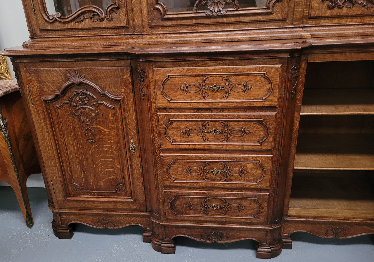 Impressive French Oak Louis 14th Style Display and Sideboard. It has 4 drawers, 2 bottom cupboards with 6 total shelves and 3 display doors with 3 shelves.  In good, detailed condition.