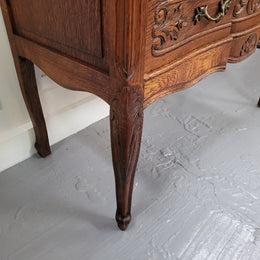 Vintage French dark Oak Louis XV style chest of three drawers. It has beautiful cabriole legs, elegant brass handles and decorative carving throughout. It is in good original detailed condition and has been sourced from France.