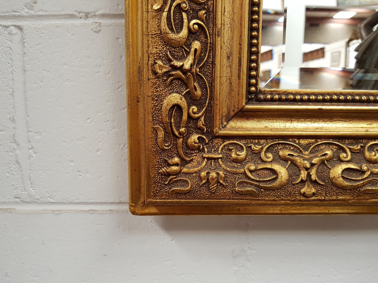 19th Century French Louis XV style gilt wall mirror with fabulous highly decorative crest at the top and a beveled edge mirror. In good original detailed condition.