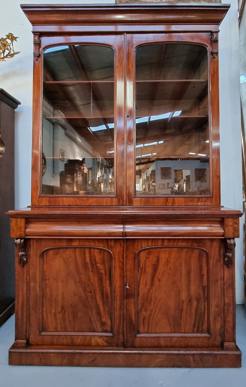 Early Victorian large flame Mahogany bookcase. Plenty of storage room with two doors and two drawers. In very good original detailed condition.