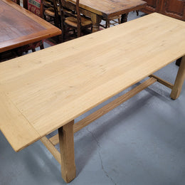 French raw Oak stretcher based refectory table. Features raw wood that could be used as is for a distressed look, or finished and waxed for a more refined look. Sourced from France and in good original condition.