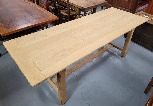 French raw Oak stretcher based refectory table. Features raw wood that could be used as is for a distressed look, or finished and waxed for a more refined look. Sourced from France and in good original condition.