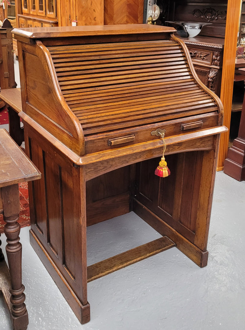 Charming petite English Oak fitted roll top desk. It has a very lovely fitted interior and a drawer at the front ideal for a unit or apartment. Sourced locally and in good original detailed condition.