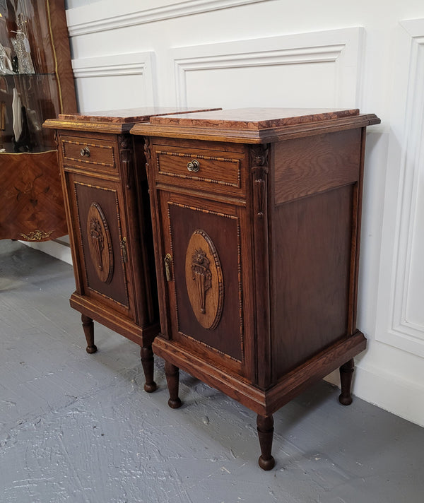 Pair of French Art Deco Oak and rouge inset marble top bedside cabinets. They have one drawer and one cupboard with elegant carving on the door. They have been sourced from France and are in good original detailed condition.