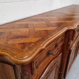 A Beautifuuly cavered French Walnut Louis XV style four door sideboard. Plently of storage space with four doors as well as four drawers. It is in good original detailed condition.