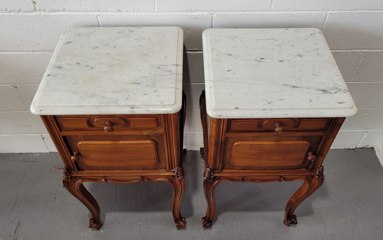 Pair of stunning Louis XV style French Walnut white marble top bedside cabinets. They have one drawer and a cupboard that is marble lined. The marble has been polished and they are in good original detailed condition.