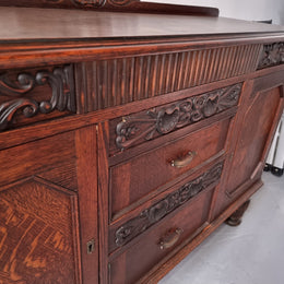 Art Deco Tudor style Oak sideboard with decorative carved detail. Plenty of storage space with two cupboards and four drawers. It has been sourced locally and is in good original detailed condition.