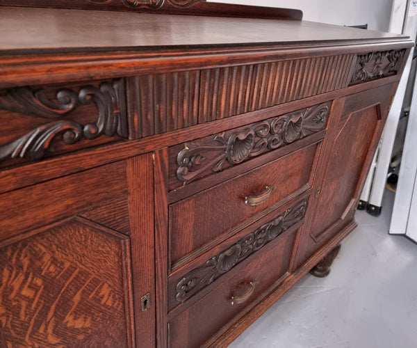 Art Deco Tudor style Oak sideboard with decorative carved detail. Plenty of storage space with two cupboards and four drawers. It has been sourced locally and is in good original detailed condition.