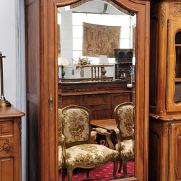 French Louis XV style Walnut armoire with single bevelled mirrored door. It has four adjustable shelves and a hidden exterior drawer at the bottom. It has been sourced from France and is in good original detailed condition.
