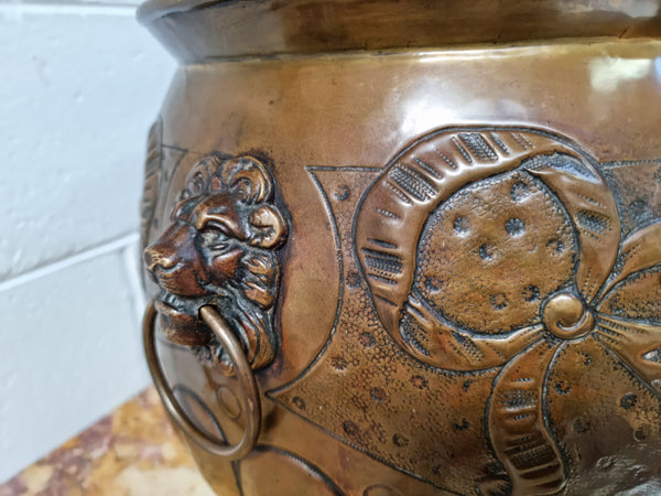 Antique large brass bronze coloured embossed Jardinière/planter with lovely details and lion heads for handles. It is in good original condition.