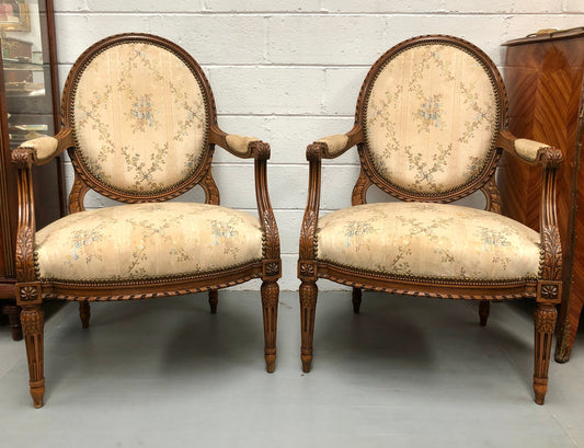 Pair of Antique French Louis XVI style carved Walnut fauteuils in restored condition. The Tapestry upholstery is in good condition some marks and wear but usable.