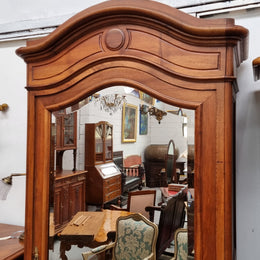 French Louis XV style Walnut armoire with single bevelled mirrored door. It has four adjustable shelves and a hidden exterior drawer at the bottom. It has been sourced from France and is in good original detailed condition.