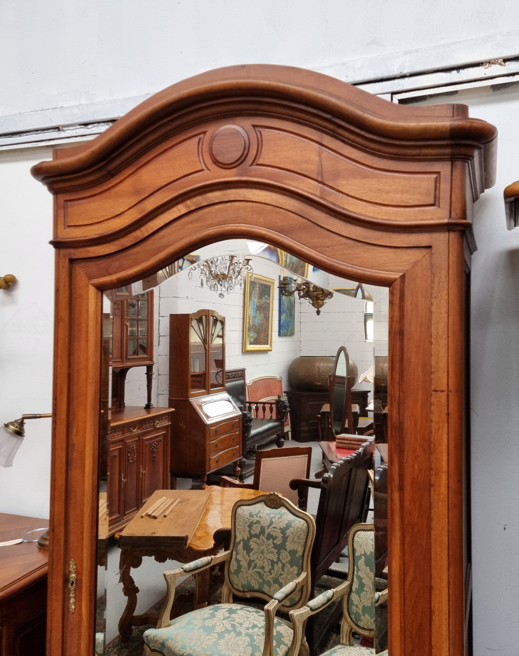 French Louis XV style Walnut armoire with single bevelled mirrored door. It has four adjustable shelves and a hidden exterior drawer at the bottom. It has been sourced from France and is in good original detailed condition.
