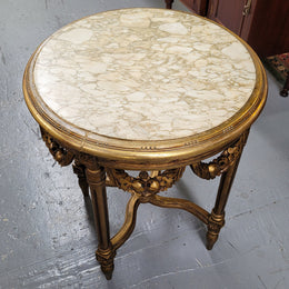 French Louis XVI style round marble topped gilded lamp/side table featuring lovely carved swags and undercarriage. It has been sourced from France and is in good original detailed condition.