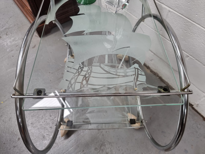 Stylish Art Deco chrome & frosted glass drinks trolley. Bakelite guards on the wheels. It is in good original condition and has been sourced locally.