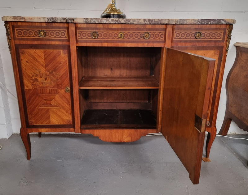 A high quality 19th Century French marquetry inlaid Kingwood marble top credenza. It has an attractive solid marble top and decorative marquetry inlay throughout. It has plenty of storage space with three drawers and three doors. It has been sourced from France and is in good original detailed condition.