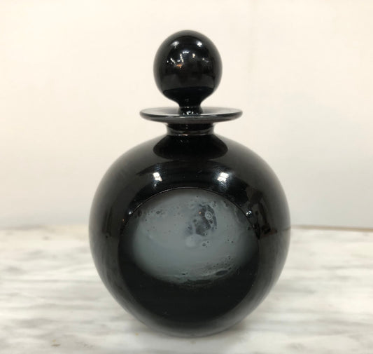 Nick Wirdnam round with one edge flat black art glass scent bottle. Signed underneath In good original condition.