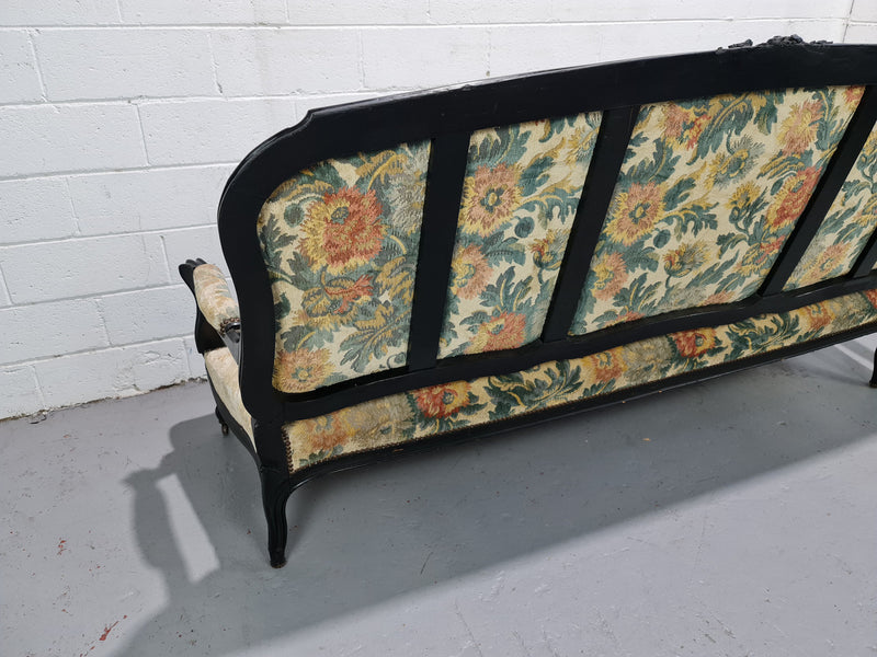 A Substantial Antique 19th Century Louis XV style ebonized serpentine front settee. The fabric is in used condition showing use and could be used as is or reupholster.