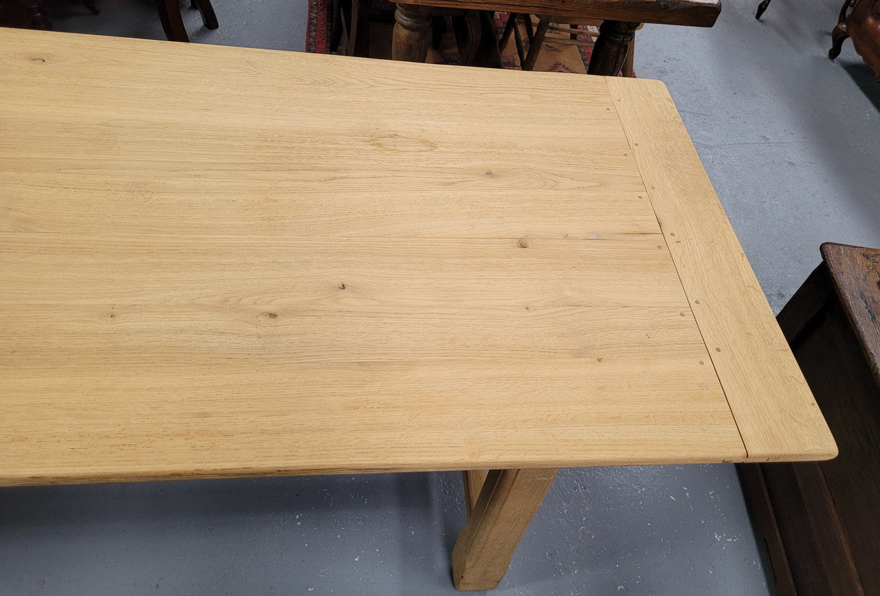 French raw Oak stretcher based refectory table. Features raw wood that could be used as is for a distressed look, or finished and waxed for a more refined look. Sourced from France and in good original condition.