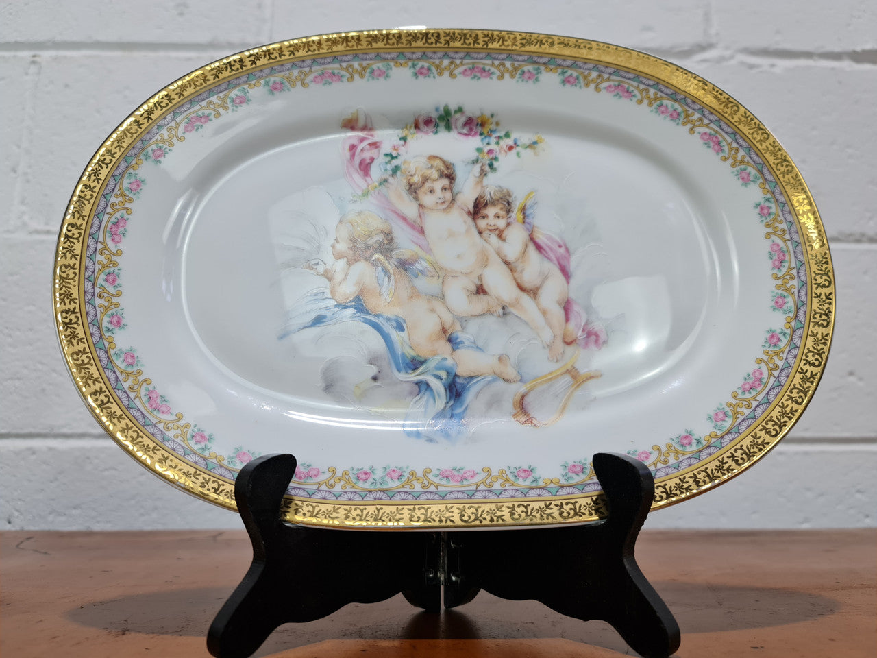 Beautiful T. Limoges porcelain decorative oval plate depicting 3 cherubs with gold edging. In good original condition.