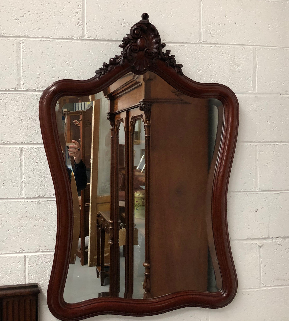 Lovely French mahogany wall mirror with carved detail, beveled glass and in good condition.
