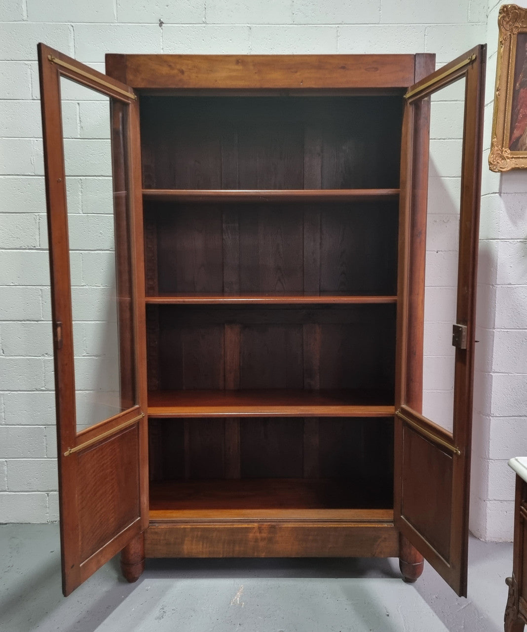 Grand French Mahogany Empire two door bookcase. It has beautiful glass doors and has three fully adjustable shelves. It has been sourced from France and is in good original detailed condition..