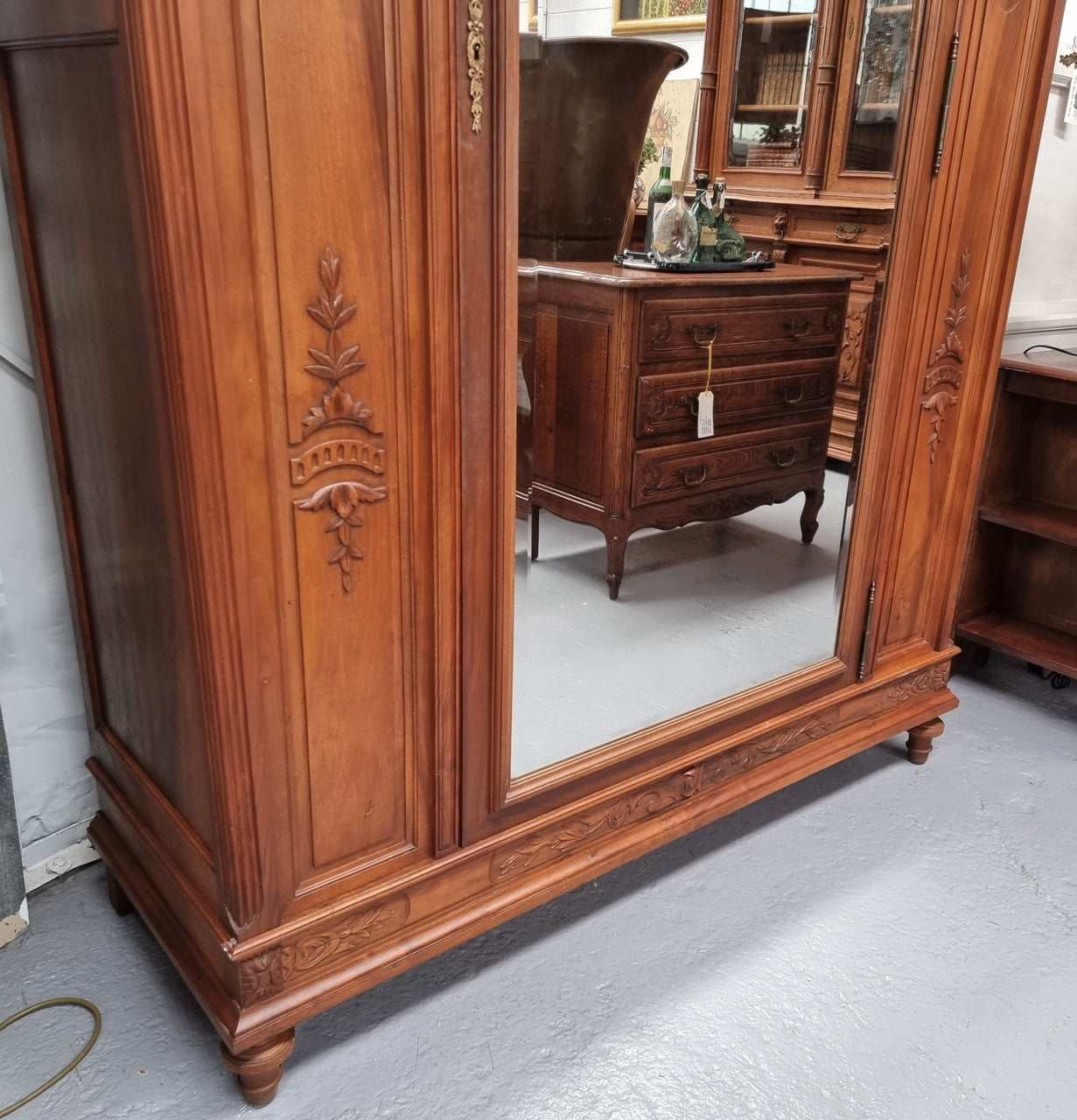 Imposing Louis XV style single mirrored door Walnut armoire. Features deep carved decoration, two interior drawers and three adjustable shelves. It is in good original detailed condition and has been sourced from France.