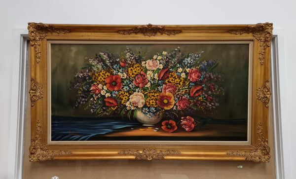 Sourced from France a stunning colorful floral oil painting on canvas. It is in a decorative gilt frame and is signed. It is in good original detailed condition.