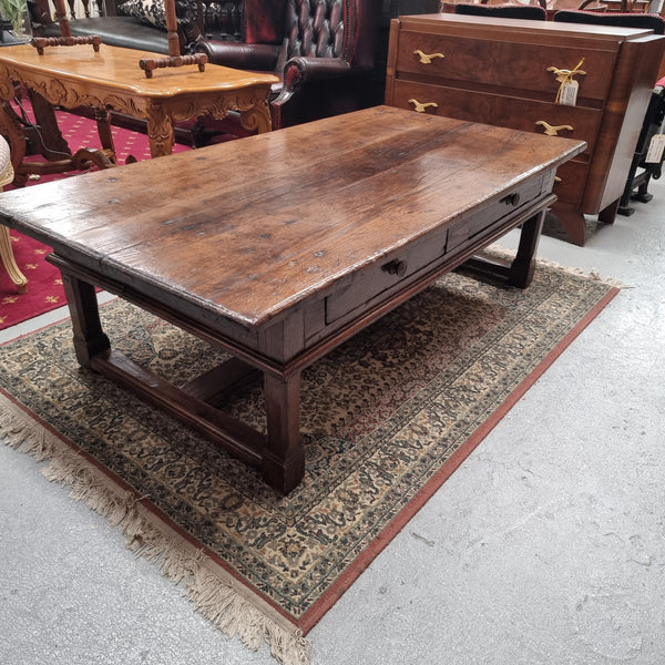 Impressive large size rustic French Oak coffee table with two drawers on a stretcher base. In good original detailed condition and sourced from France.