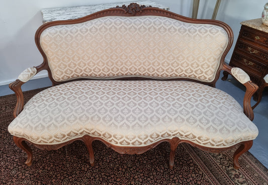 A late 19th Century French Walnut Louis XV style settee with a serpentine front. This settee upholstery is like new and is in very good condition.