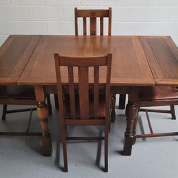 Fabulous small Oak extension table and four dining chairs. The table extends from a four seater to a six seater. The chairs have nice carvings and leather inset seats. They are in original detailed condition.