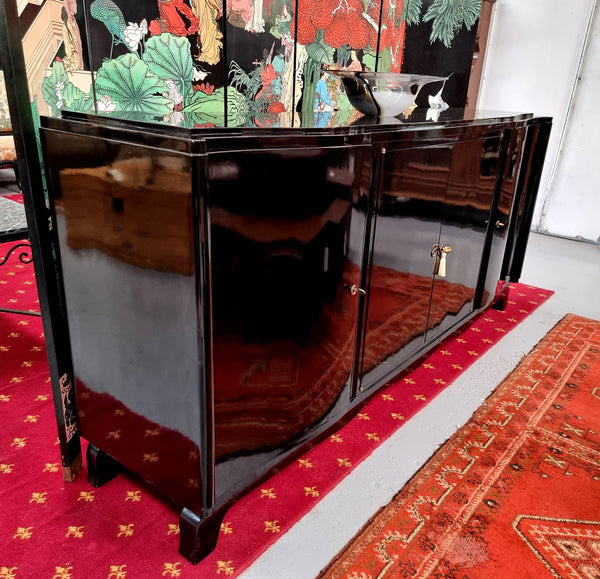 French Art Deco sideboard with a custom black lacquer finish.  Beautiful serpent shaped front with four cupboards with working locks and includes to working keys. It is in original condition.