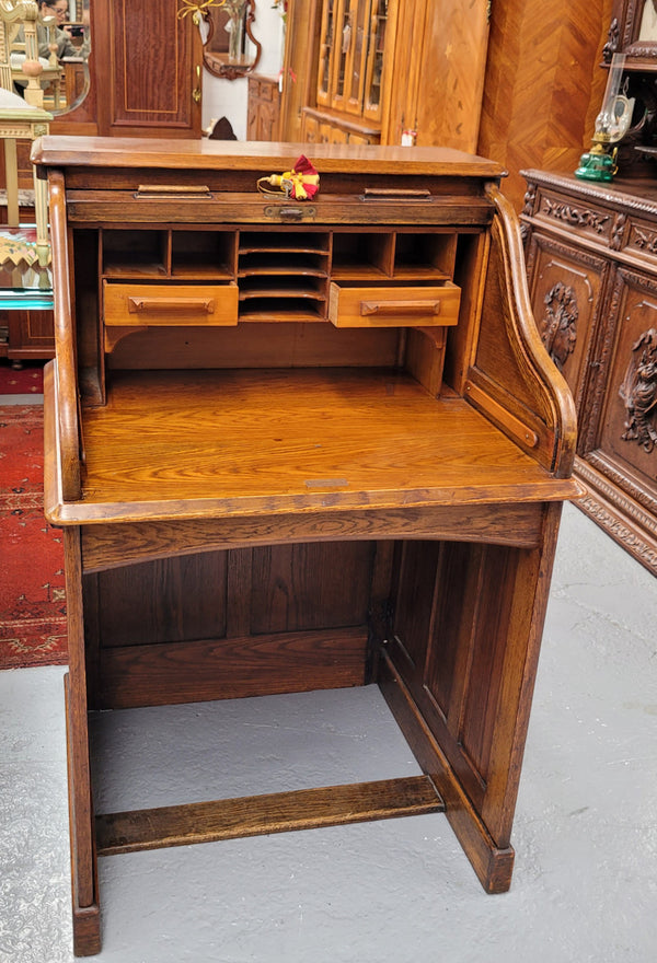 Charming petite English Oak fitted roll top desk. It has a very lovely fitted interior and a drawer at the front ideal for a unit or apartment. Sourced locally and in good original detailed condition.