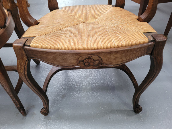 Pair of Louis XV Style Oak framed rush seated carver chairs. They have been sourced from France and in good original detailed condition.