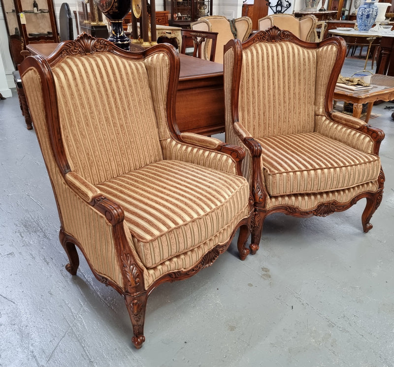 Beautiful pair of Walnut French-style newly upholstered wingback armchairs. They are in very good original detailed condition.