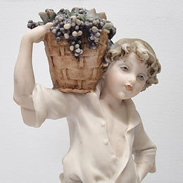 Lovely Italian figurine of boy carrying basket with grapes on a wooden base. It is signed Giuseppe Armani and 1982 FLORENCE. In good original condition.  Please view photos as they form part of the description.