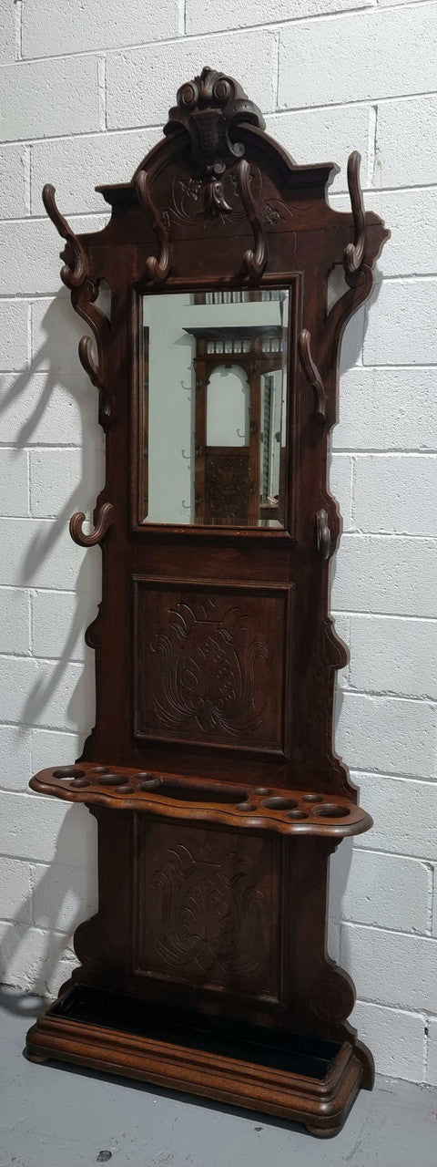 A beautiful Henry II style narrow French Oak hall stand. It has beautiful decorative carvings as well as 8 wooden hooks and storage for umbrellas and walking sticks. In good original detailed condition.